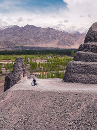 Man riding motorcycle on mountain against sky