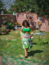 Portrait of smiling woman standing against plants