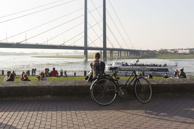 Bicycle on bridge over river in city against sky