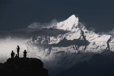 Panoramic view of people on snowcapped mountain against sky