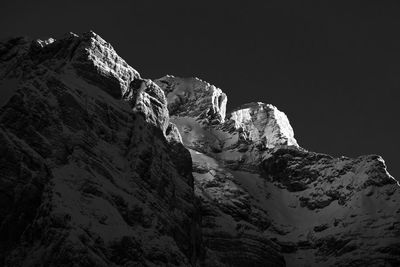 Low angle view of snowcapped mountain against sky