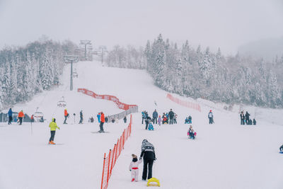 People skiing on snow covered landscape