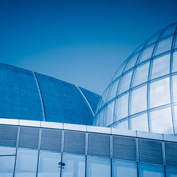 Low angle view of modern building against clear blue sky