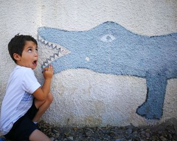 Portrait of cute boy against wall