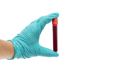 Close-up of human hand holding umbrella against white background