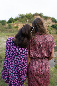 Rear view of woman with arms raised on field