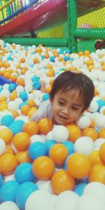 Portrait of smiling boy with multi colored balloons