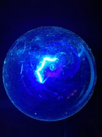 Close-up of illuminated light against blue background