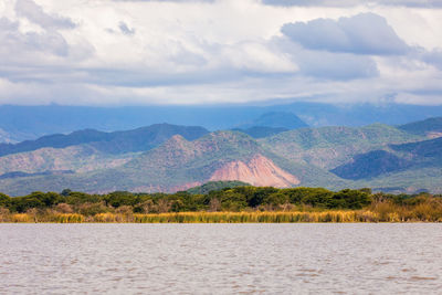 Scenic view of lake against cloudy sky