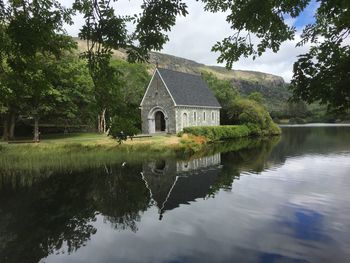 Reflection of building in lake against sky