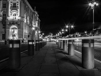 Illuminated street amidst buildings in city at night