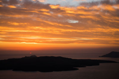 Scenic view of sea against dramatic sky during sunset