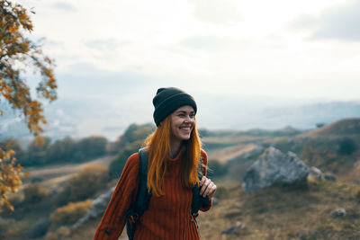 Young woman looking away while standing outdoors