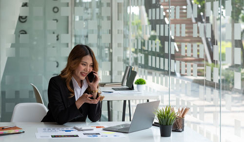 Businesswoman talking on phone at office