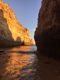 Rock formation on sea shore against sky