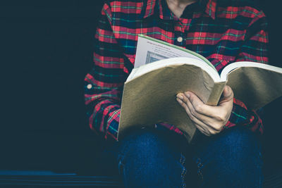 Midsection of woman reading book