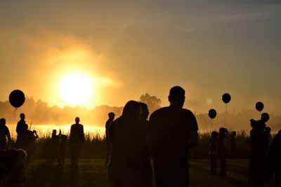 Rear view of people at sunset