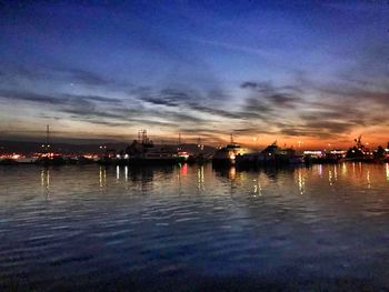 Scenic view of harbor against sky at sunset