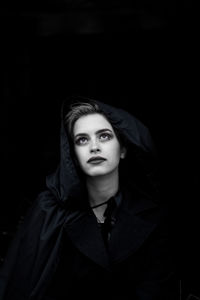 Young woman looking up against black background