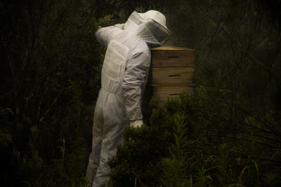 Man standing by beehive