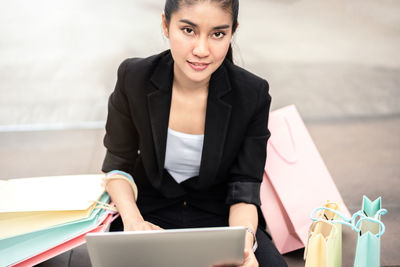 Portrait of young woman using smart phone on table