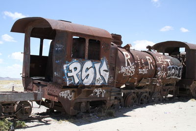 Abandoned train on railroad track against sky