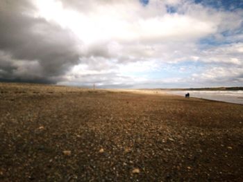 Scenic view of field against cloudy sky