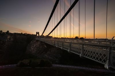 Bridge over road against sky during sunset