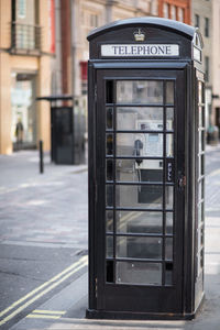 Close-up of telephone booth on sidewalk