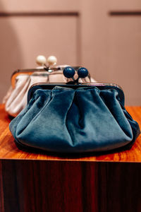 Velvet blue and white clutches on a wooden stand. fashion details, women's accessories