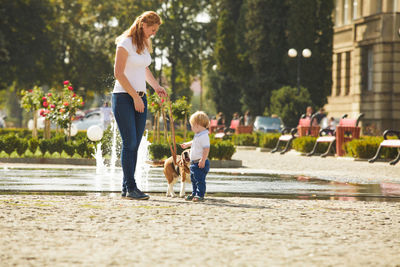 Mother and son with dog in city