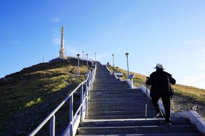 Rear view of woman walking at staircase on mountain