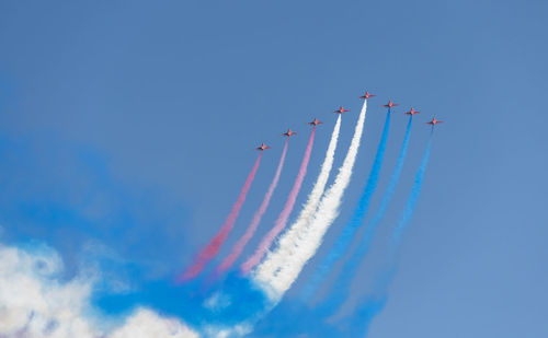 Low angle view of airplane flying against blue sky