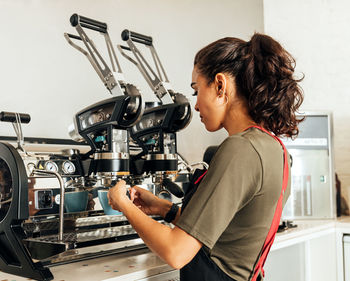 Side view of woman using coffee at home