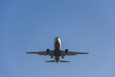 Low angle view of airplane flying against clear sky