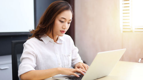 Young woman using laptop at home