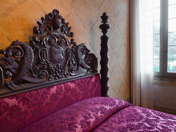 Close-up of ornate window on bed at home