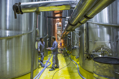 Worker controlling stainless steel tanks for food industry