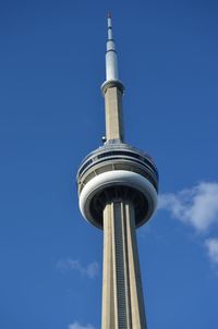Low angle view of communications tower in city against sky