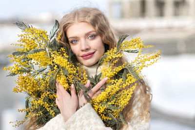 A woman with a bouquet of yellow acacia flowers. spring holiday - march 8, easter, women's day