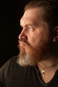 Close-up portrait of man against black background