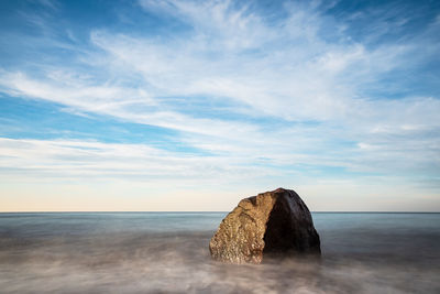 Scenic view of rocks in sea against sky