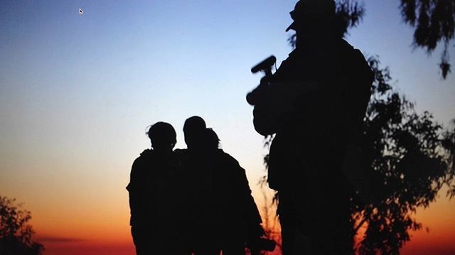 silhouette, sunset, men, sky, leisure activity, lifestyles, togetherness, clear sky, standing, person, orange color, nature, bonding, dusk, tranquility, beauty in nature, sea, scenics