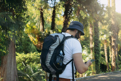 Rear view of woman standing in forest