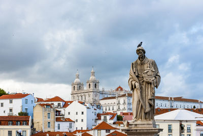 Statue of buildings against cloudy sky