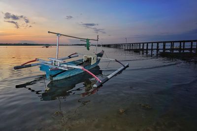 Boats in sea against sky during sunset