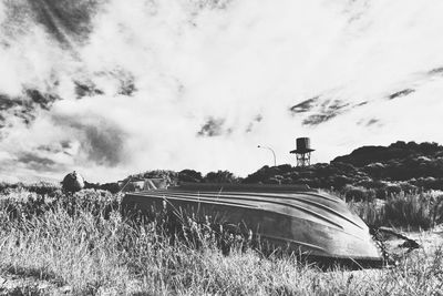 View of field against cloudy sky
