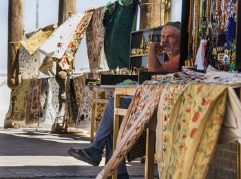 Side view of man sitting on wall