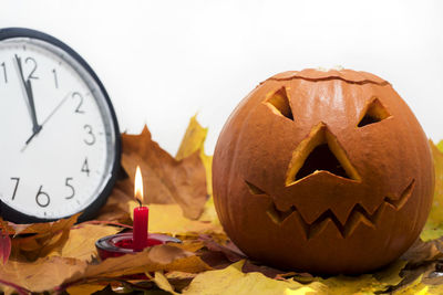 Close-up of pumpkin on table against wall during halloween