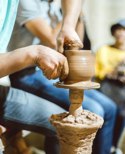 Midsection of man working on pottery wheel